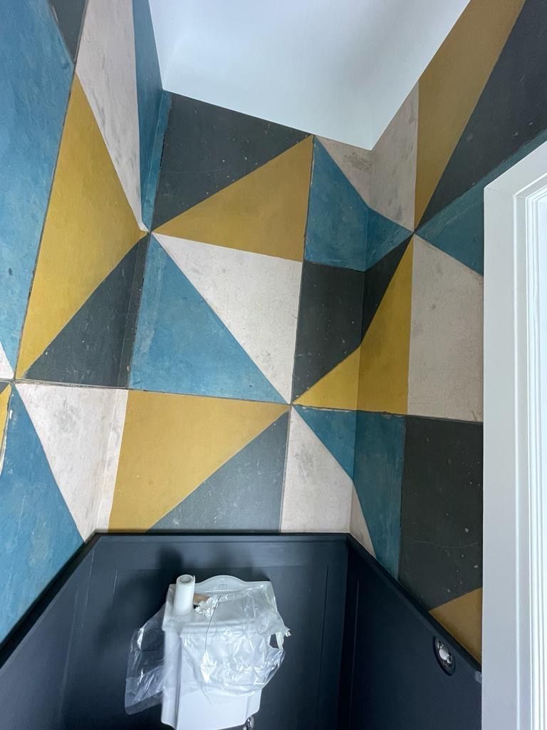 eine Toilette in einem Badezimmer mit einem geometrischen Muster an der Wand.