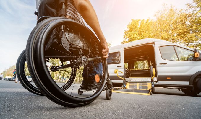 Fauteuil roulant s'approchant d'un minibus adapté aux PMR