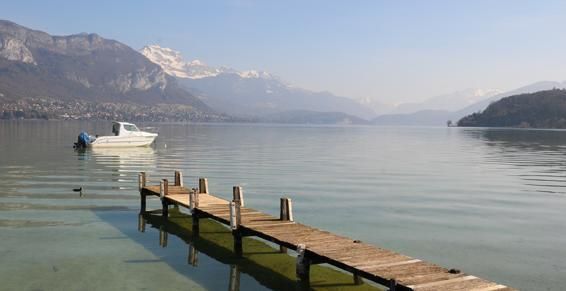 Bateau derrière le ponton en bois sur le lac d'Annecy