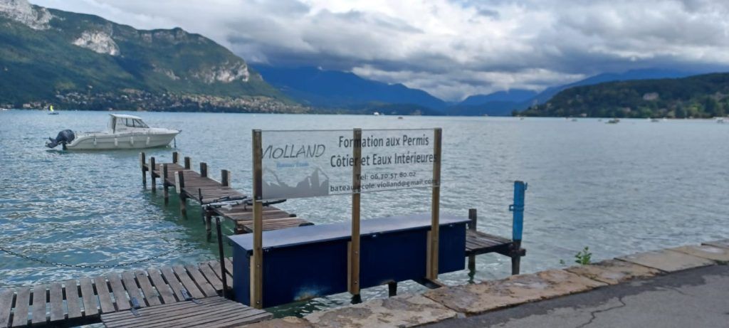 Ponton en bois sur le lac d'Annecy avec un ciel bleu