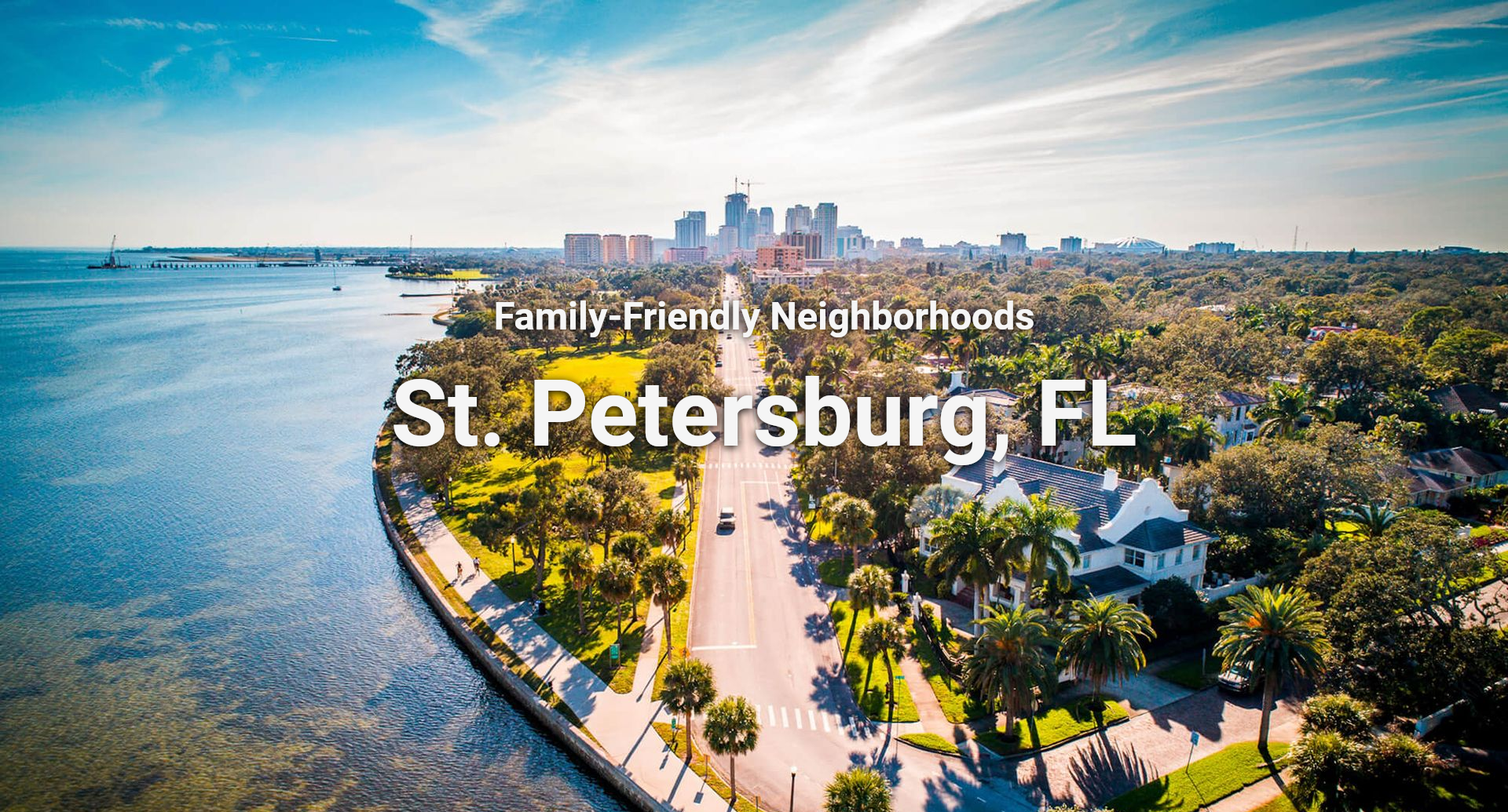 Aerial view of St. Petersburg, Florida. Skyscrapers, waterway, road with cars, and trees dominate the landscape.