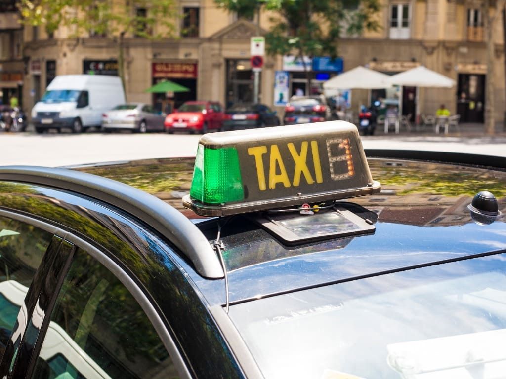 Un taxi está estacionado al costado de la carretera en una ciudad.