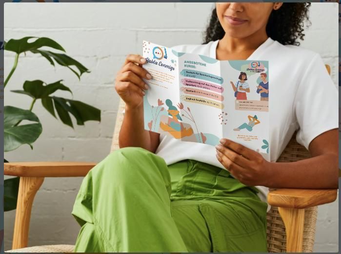 Eine Frau sitzt auf einem Stuhl und liest eine Broschüre.