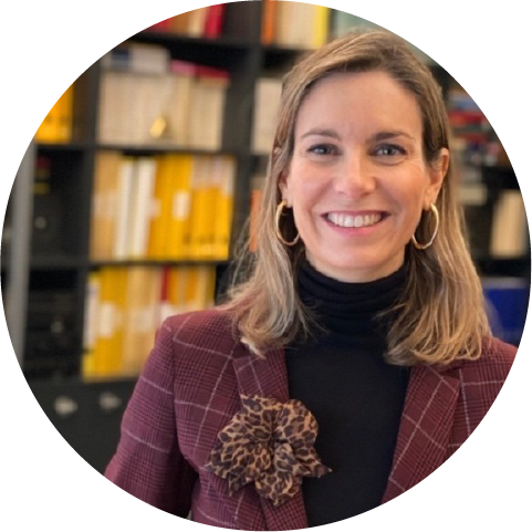 Una mujer que lleva un broche con estampado de leopardo sonríe a la cámara.