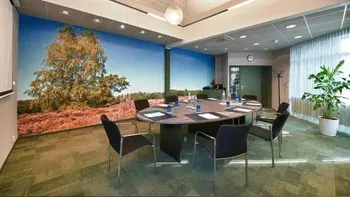 Een conferentieruimte met een ronde tafel en stoelen