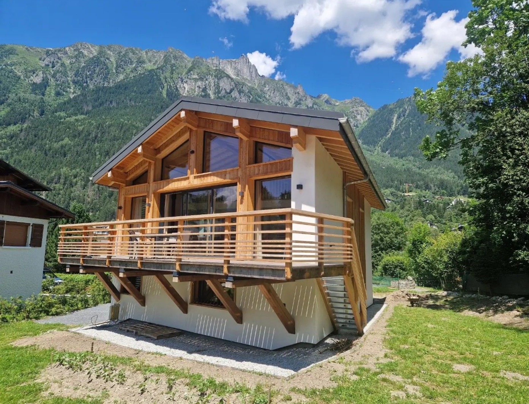 Chalet en bois avec balcon, niché face aux montagnes.