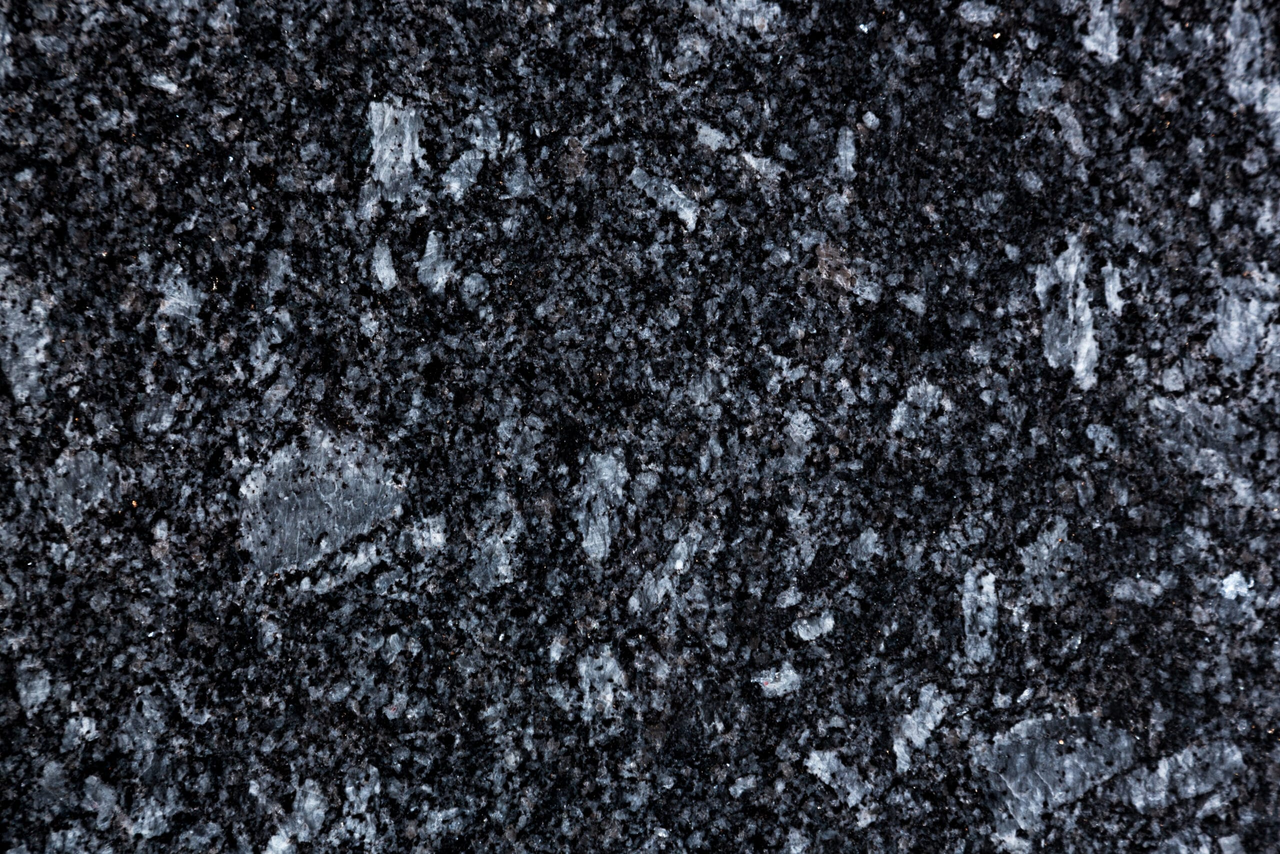 Surface en granit noir avec des taches cristallines réfléchissantes.
granit azul noche, granit d'Espagne 