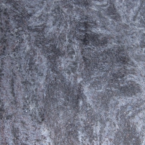 Surface semblable à du marbre gris avec des veines de couleur claire et de petites inclusions scintillantes. granit orion, granit mass blue, granit inde