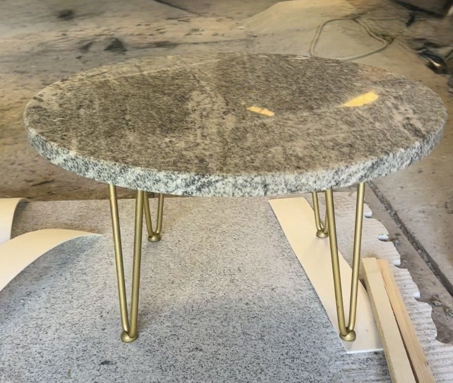 Table basse en granit gris avec pieds en épingle à cheveux en laiton.