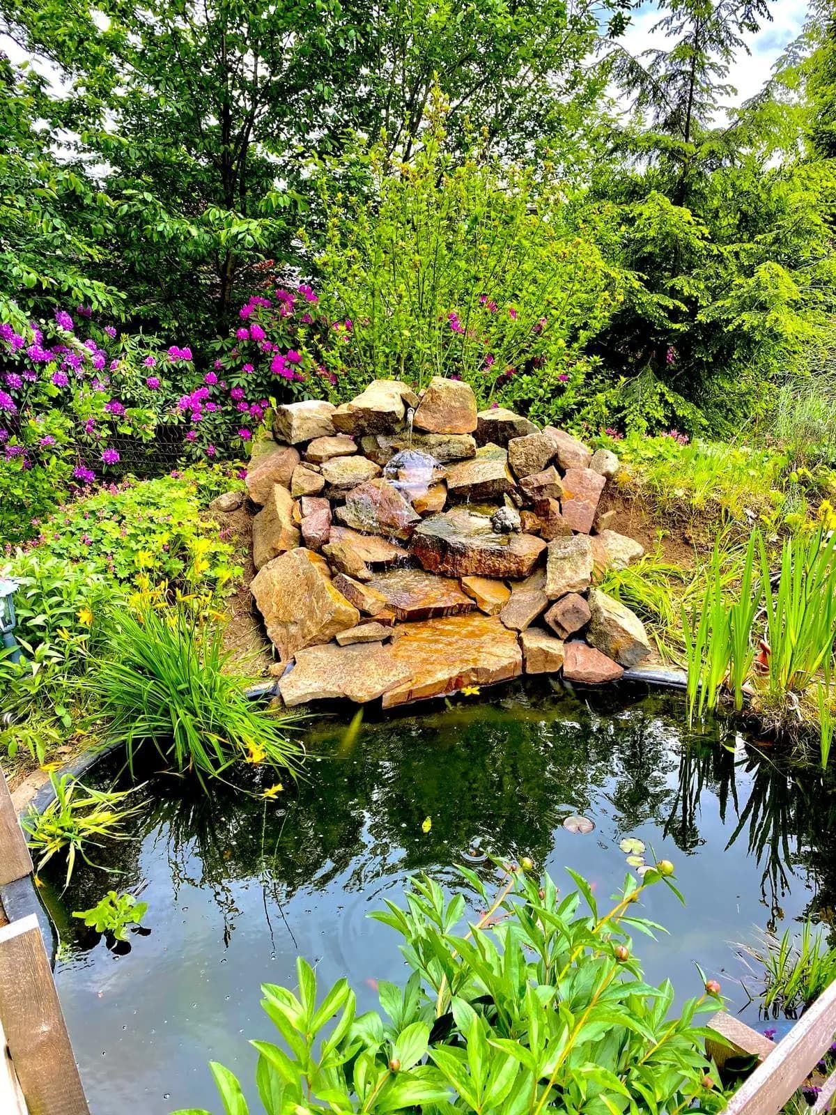 In der Mitte des Gartens befindet sich ein Teich mit Wasserfall.