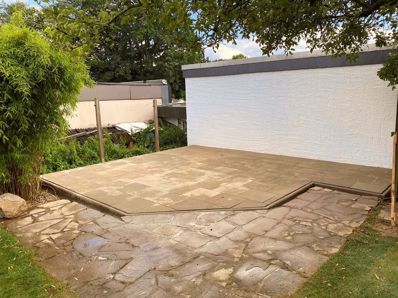 Eine Steinterrasse mit einem weißen Gebäude im Hintergrund.