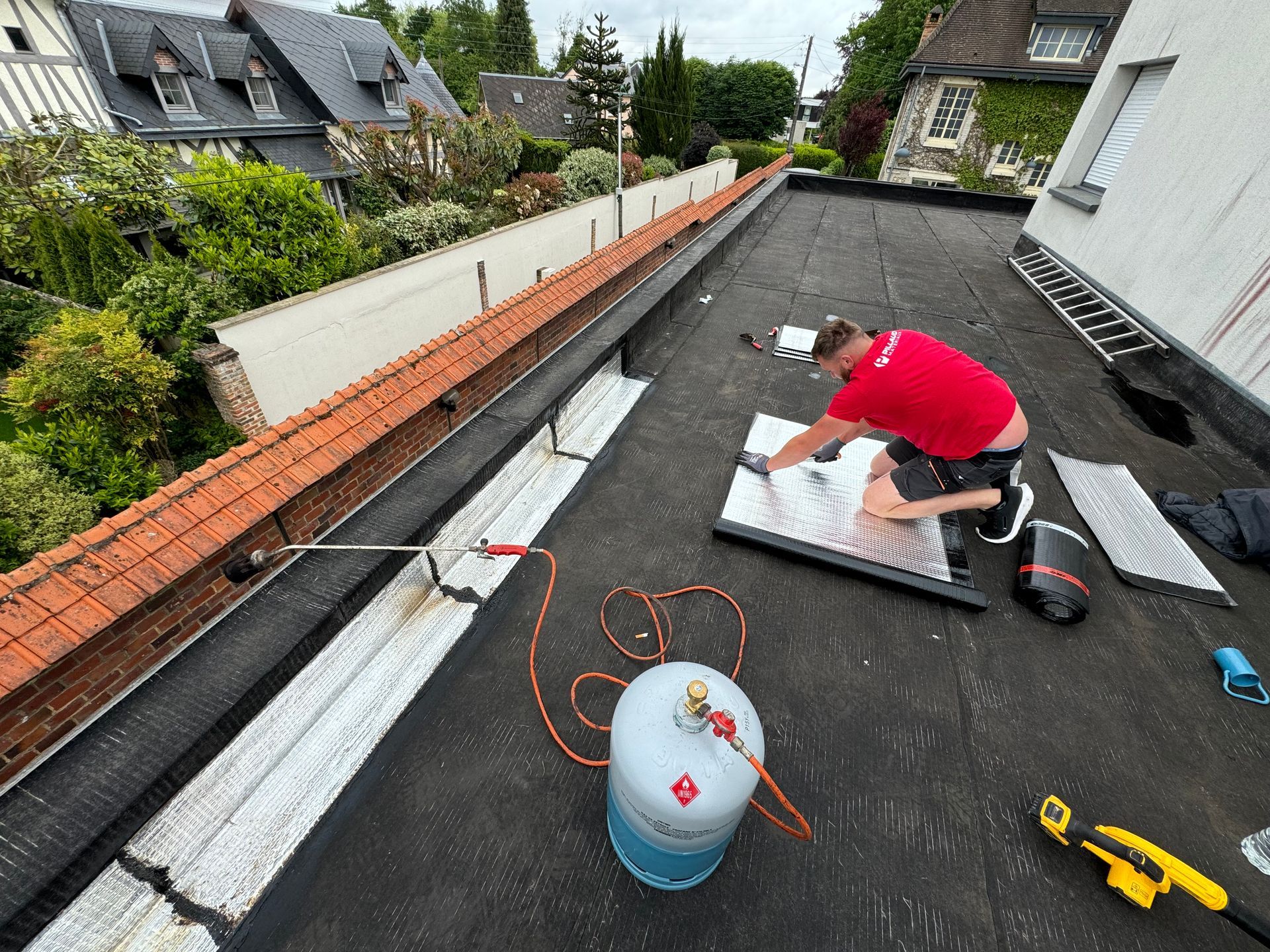 Un homme travail sur la pose du zinc sur une terrasse