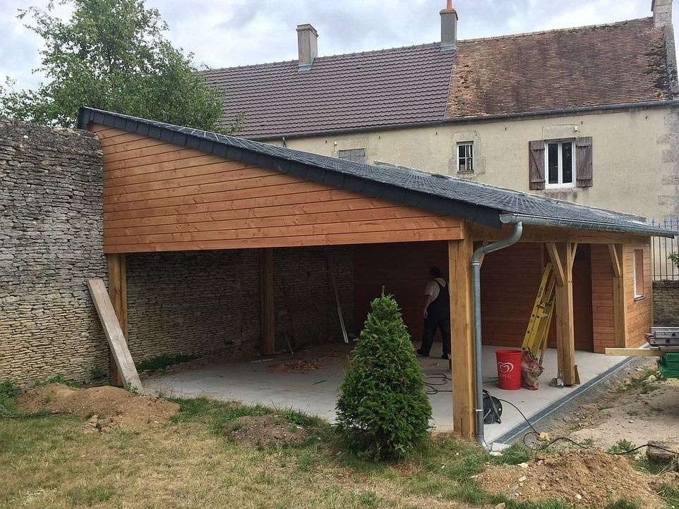 Chantier d'abri en bois contre un mur de pierre