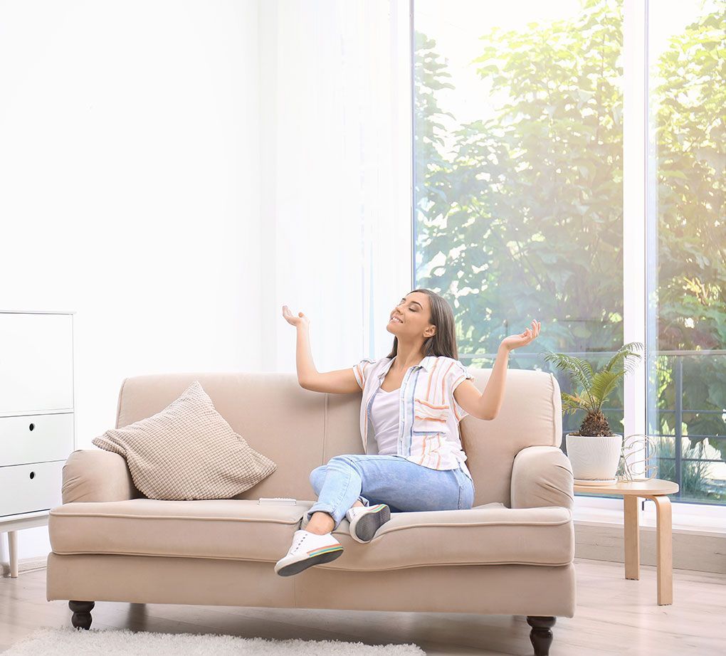 Femme dans son canapé qui profite du confort de son logement