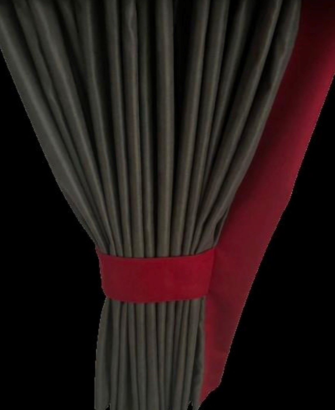 Eine Nahaufnahme eines Vorhangs mit einer roten Schleife auf schwarzem Hintergrund.