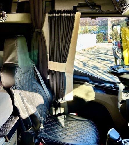 Das Innere eines Sattelschleppers mit Vorhängen auf den Sitzen.