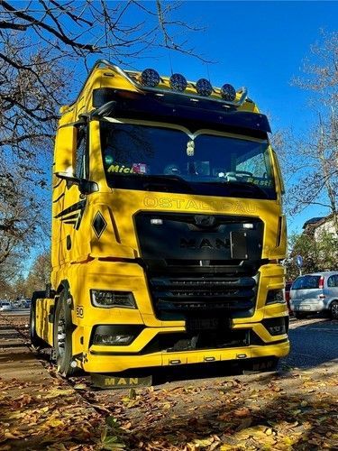 Ein gelber Lastwagen steht am Straßenrand.