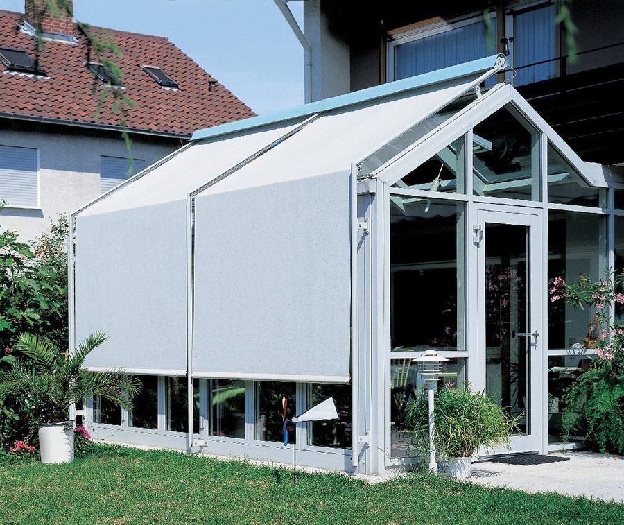 Ein Gewächshaus mit einer weißen Markise an der Seite