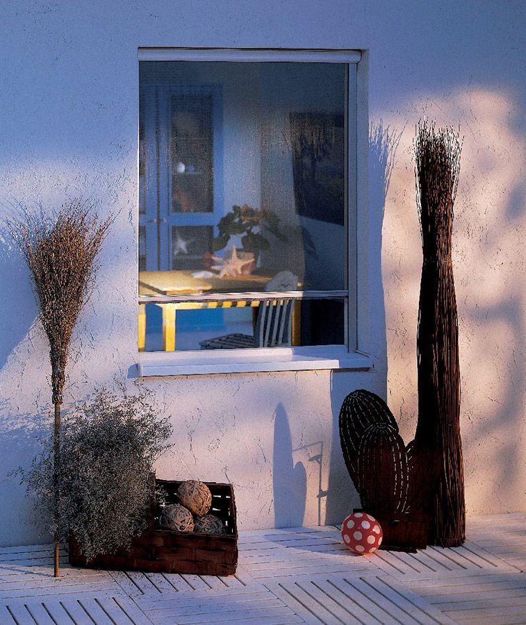 Ein Fenster mit einem Tisch und Stühlen dahinter