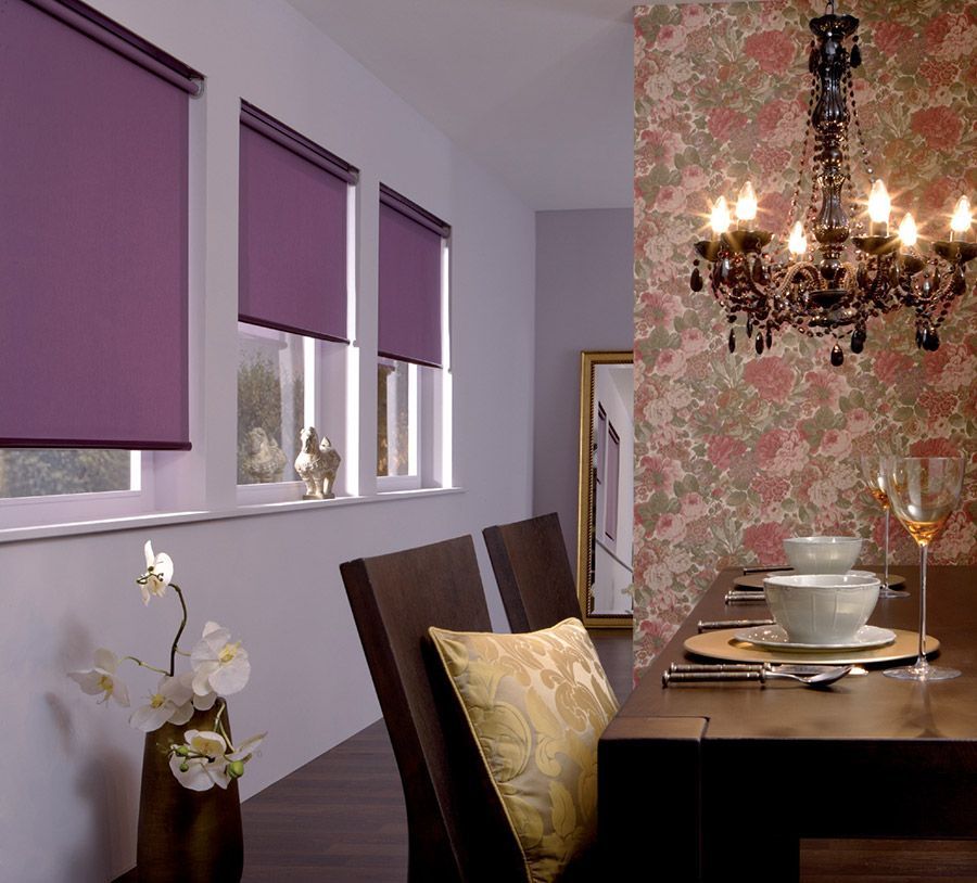 Ein Esszimmer mit lila Jalousien und einem Kronleuchter
