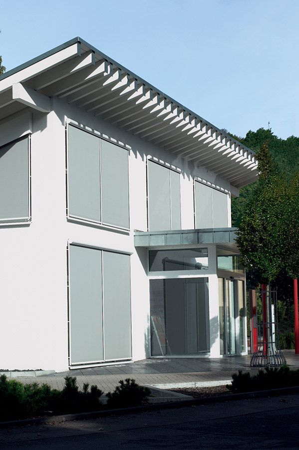 Ein weißes Gebäude mit einem Dach und vielen Fenstern