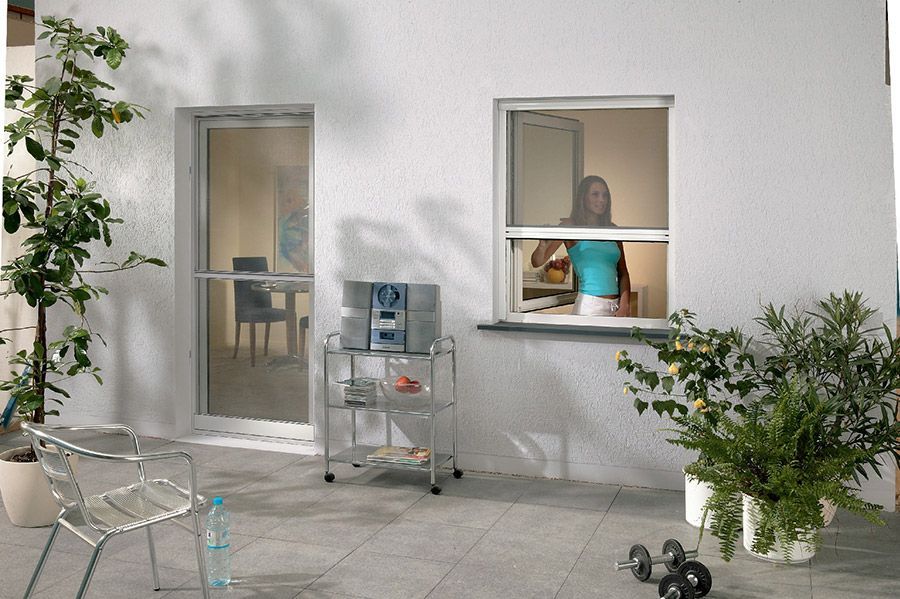 Eine Frau schaut aus einem Fenster auf eine Terrasse