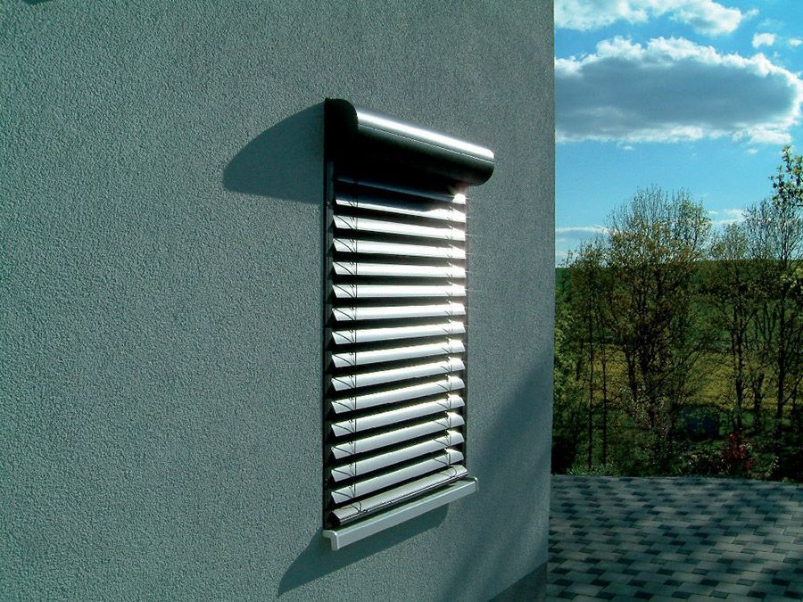 Ein Fenster mit Jalousien befindet sich an der Seite eines Gebäudes