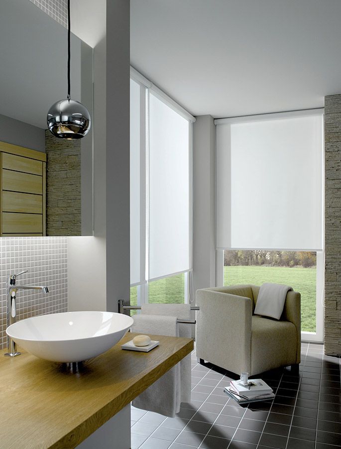 Ein Badezimmer mit Waschbecken, Stuhl und großem Fenster