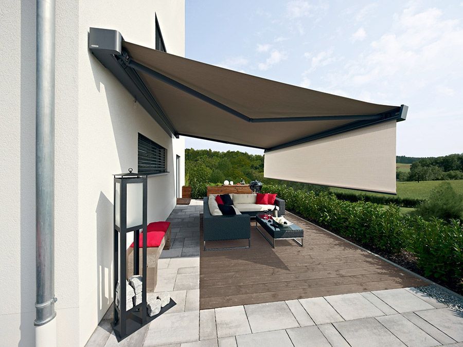 Eine Terrasse mit einer Couch und einem Tisch unter einer Markise