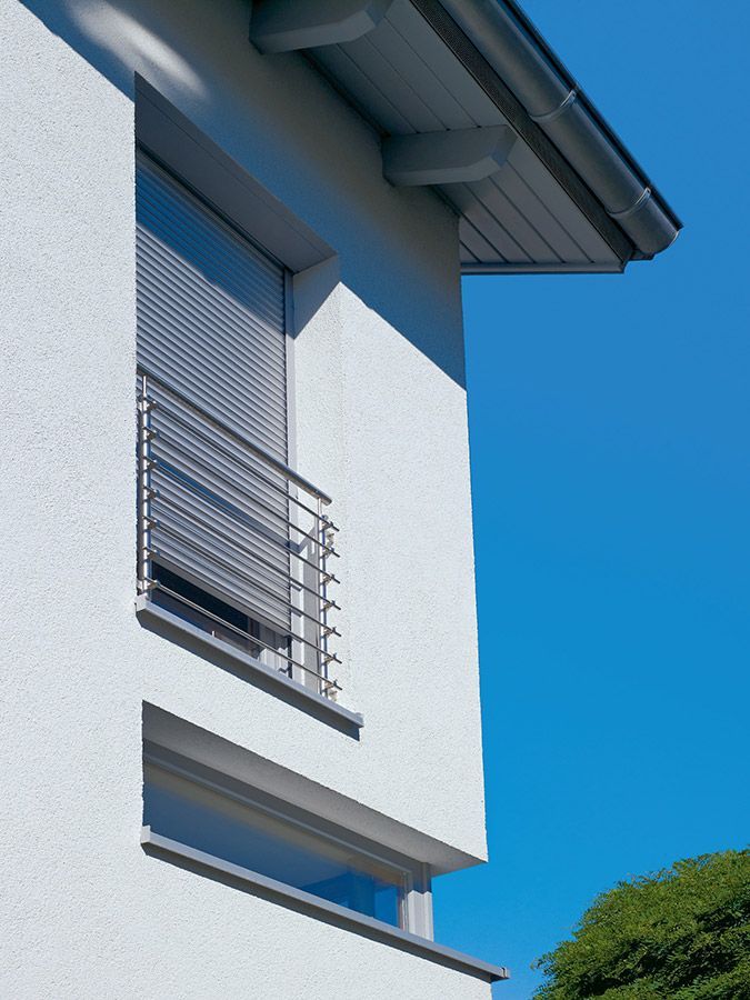 Ein weißes Gebäude mit einem Balkon und einem blauen Himmel im Hintergrund