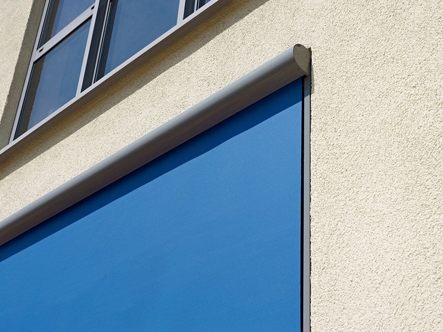 Ein Gebäude mit einer blauen Jalousie an der Seite