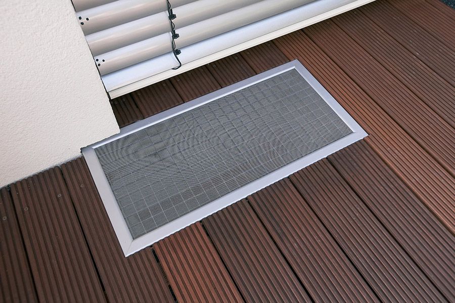 Ein Bildschirm auf einem Holzdeck neben einem Fenster