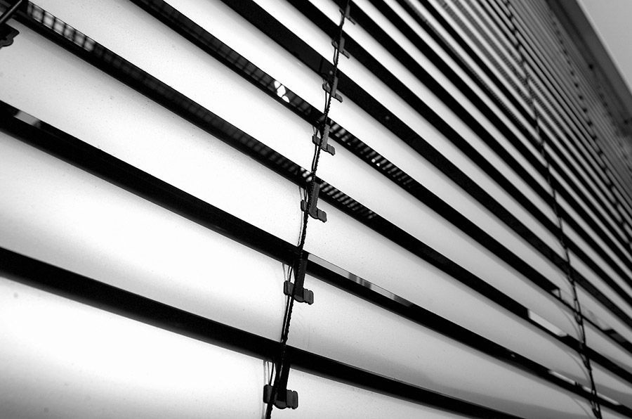 Ein Schwarzweißfoto eines Gebäudes mit Jalousien