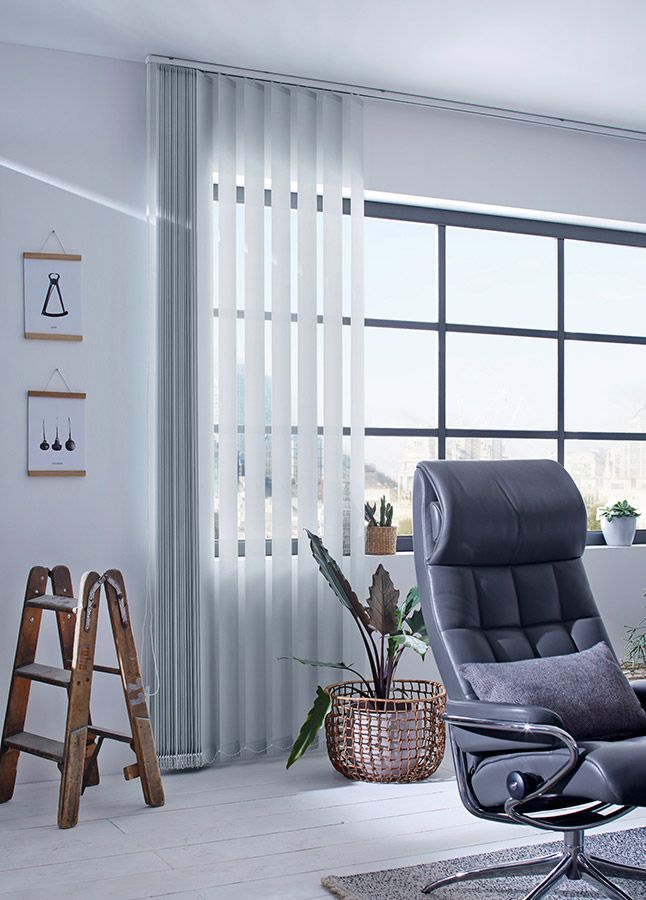 Ein Wohnzimmer mit einem Stuhl und einer Leiter vor einem Fenster.