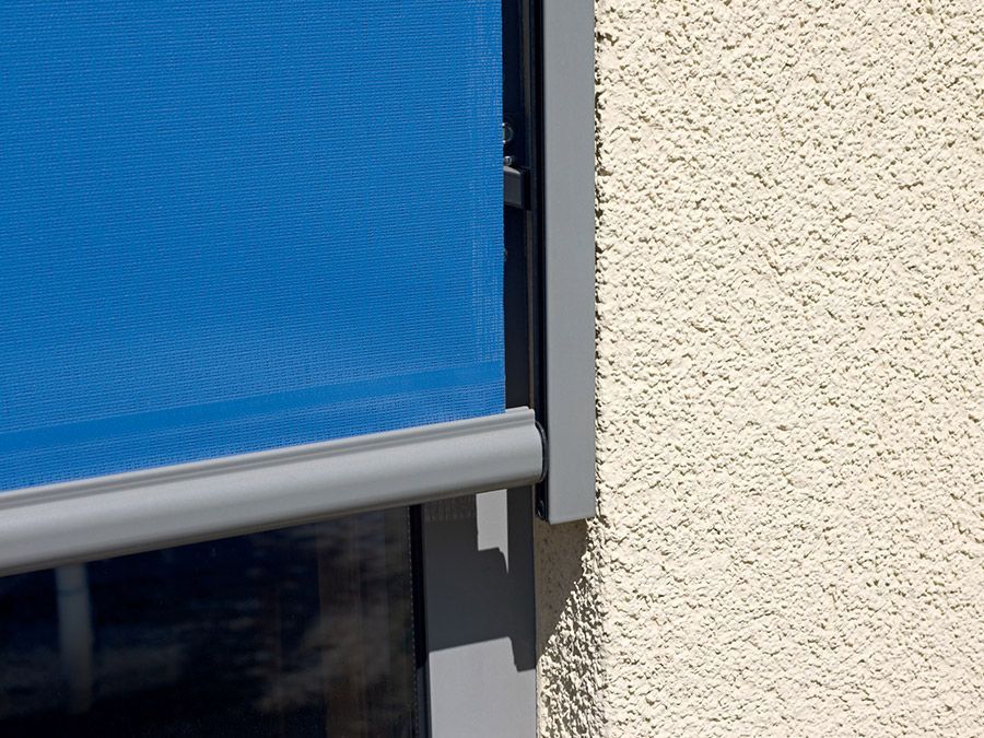 Eine blaue Markise hängt an der Seite eines Gebäudes