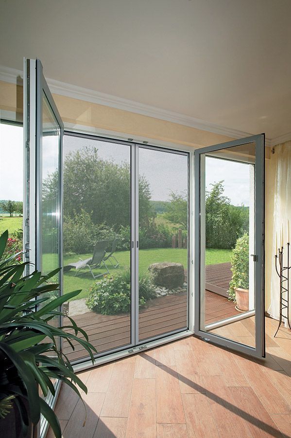 Ein Wohnzimmer mit einer Glasschiebetür, die auf eine Terrasse führt.