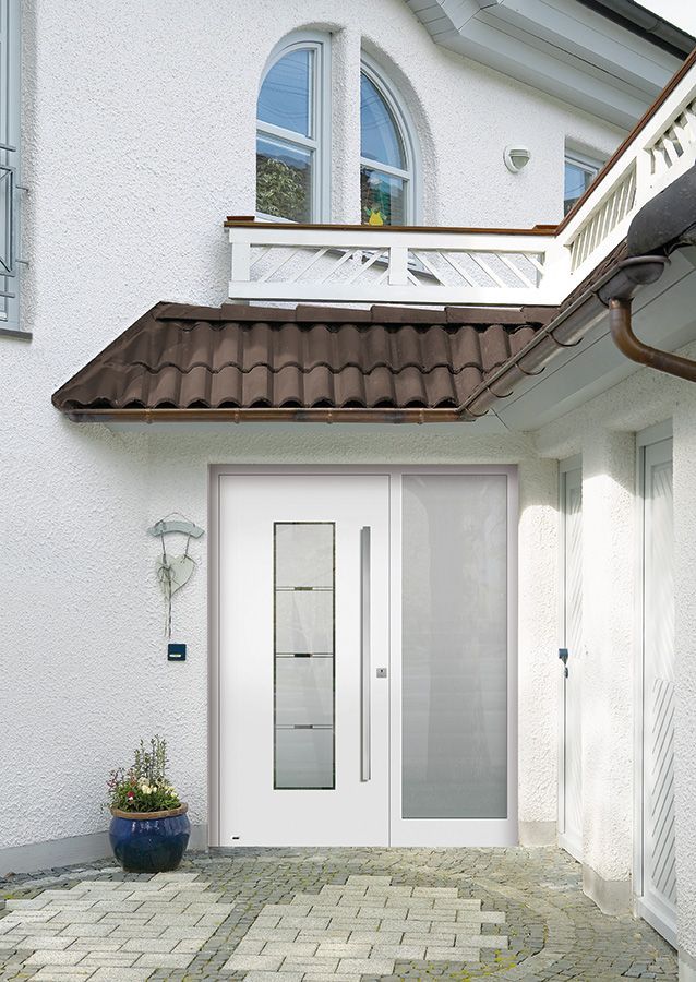 Ein weißes Haus mit einem braunen Dach und einer weißen Tür