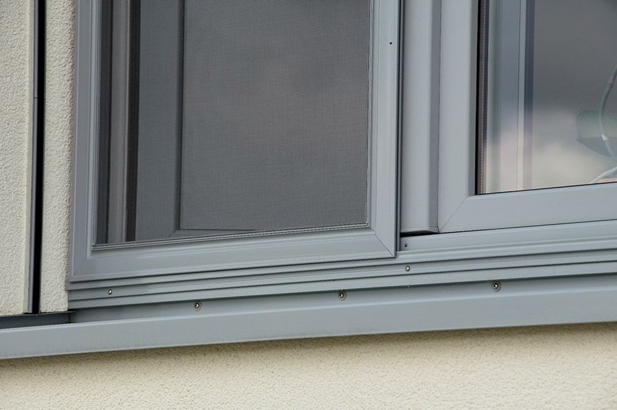 Eine Nahaufnahme eines Fensters mit einer Glasschiebetür an einem Gebäude.