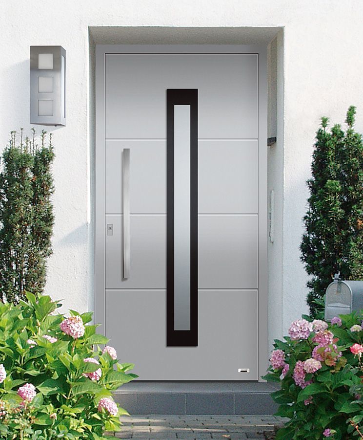 Eine weiße Tür mit einem schwarzen Griff ist von Blumen umgeben