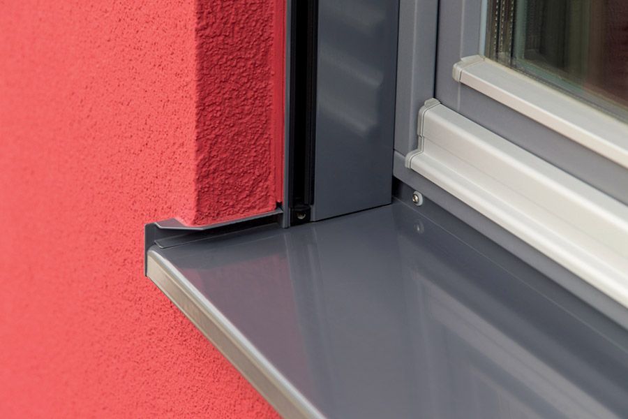 Eine Nahaufnahme einer Fensterbank an einer roten Wand.