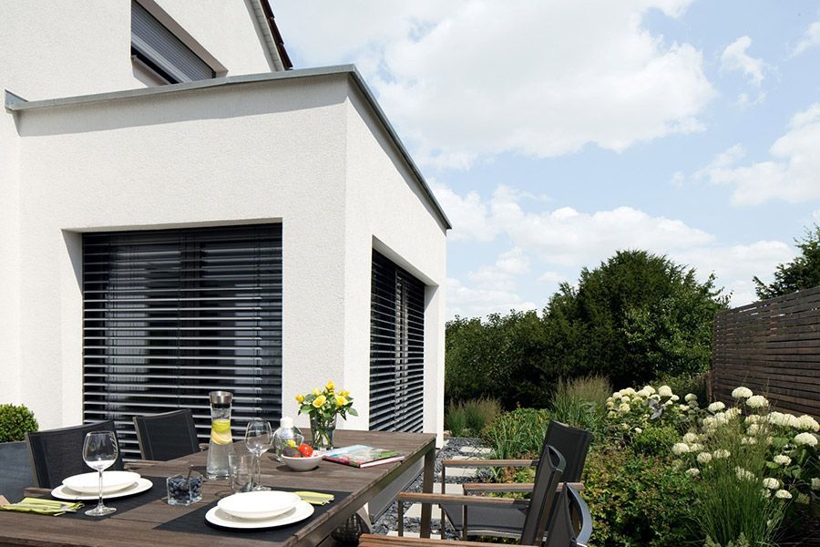 Ein Tisch mit Tellern und Gläsern darauf vor einem Haus