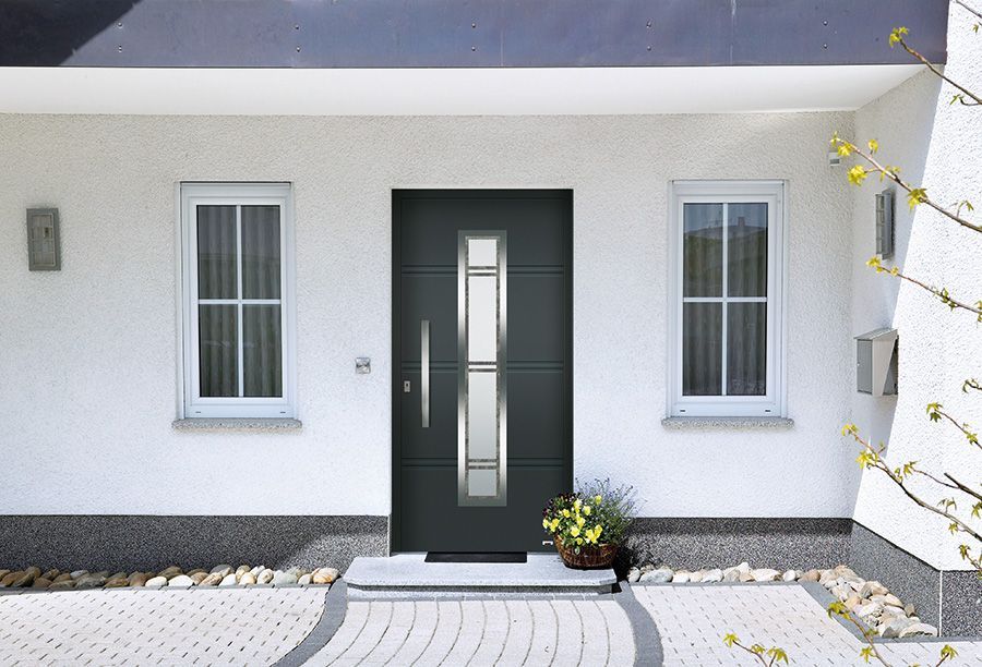 Ein weißes Haus mit einer schwarzen Tür und zwei Fenstern