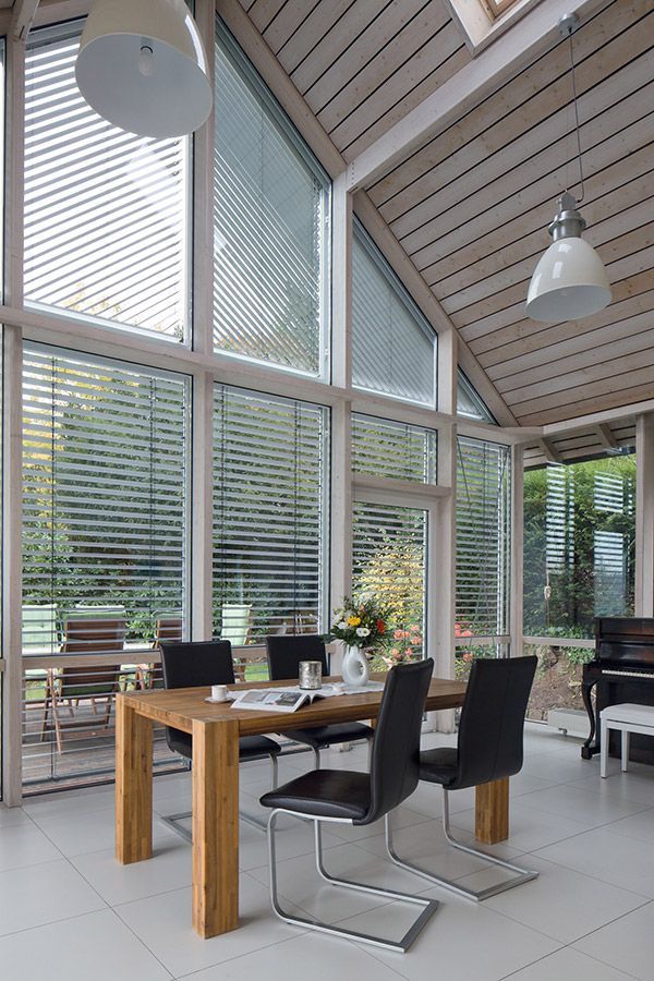 Ein Esszimmer mit Tisch und Stühlen und einem Klavier.