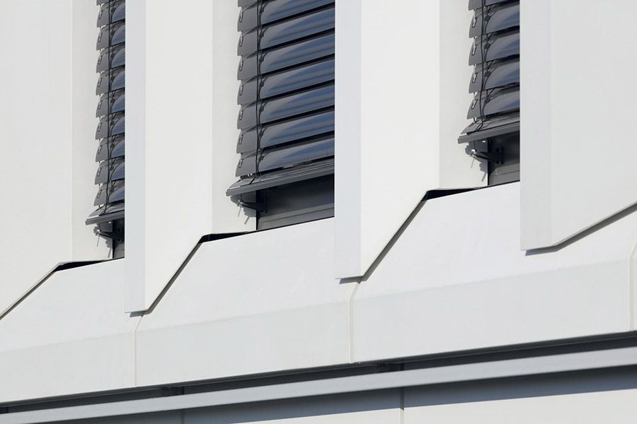 Eine Nahaufnahme eines Gebäudes mit einer Reihe von Fenstern mit Jalousien.