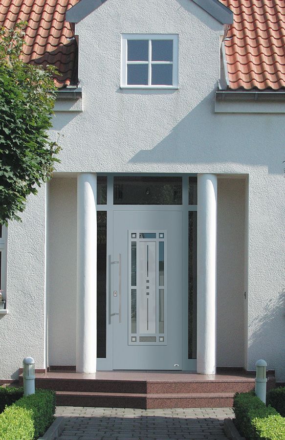 Ein weißes Haus mit einem roten Ziegeldach und einer weißen Tür