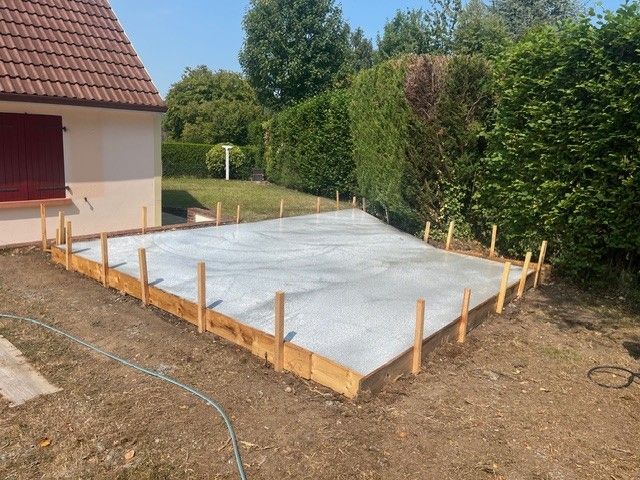 Dans un chantier de construction, des panneaux de plaques de plâtre blanc sont installés sur une isolation en mousse jaune fixée sur des montants métalliques.