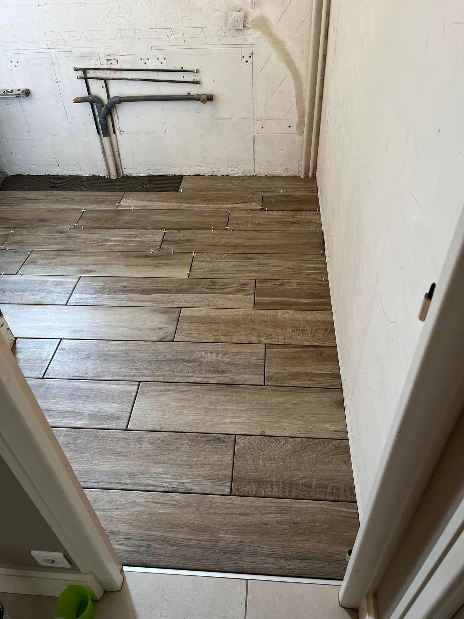 Vue en coupe diagonale d'un parquet, montrant une face poncée et claire contrastant avec une face teintée, brun doré.