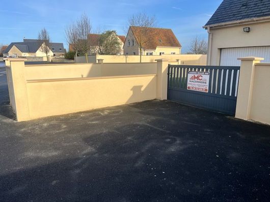 Une personne utilise une meuleuse d'angle pour découper une dalle de béton sur une terrasse en pierre.