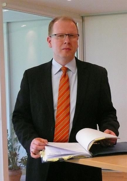 Ein Mann in Anzug und Krawatte hält ein Buch