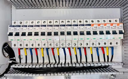 Un électricien travaille sur un coffret électrique.